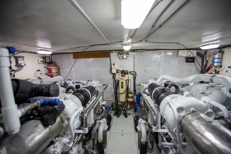 Slide: The Image of Engine room of a 1999 Tarrab Motor Yacht, featuring dual engines and mechanical equipment. - 43