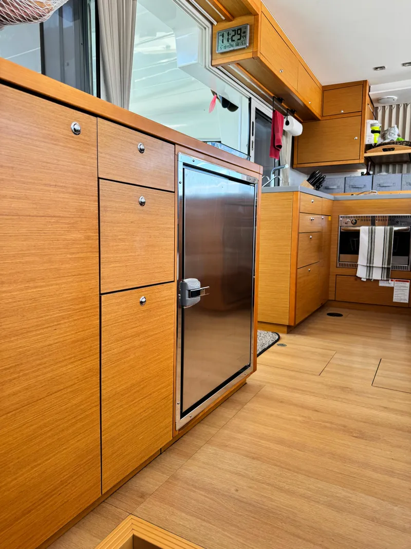 Slide: The Image of Modern kitchen interior of 2016 Lagoon 450S yacht with wooden cabinetry and stainless steel appliances. - 13