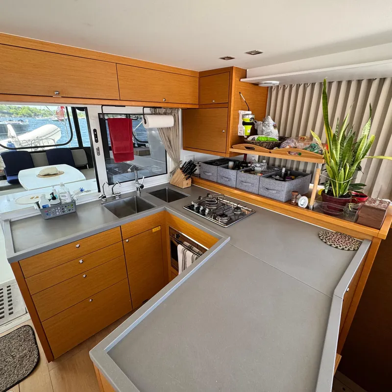 Slide: The Image of Modern kitchen interior of 2016 Lagoon 450S yacht with wooden cabinetry and sleek countertops. - 16