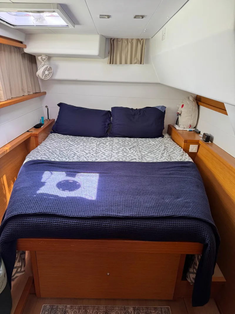 Slide: The Image of Cozy cabin bedroom in a 2016 Lagoon 450S yacht with blue bedding. - 20