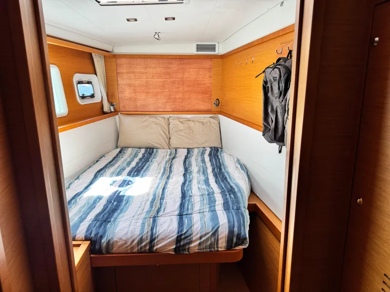 Slide: The Image of Cozy cabin interior of 2016 Lagoon 450S yacht with striped bedding and wooden accents. - 22