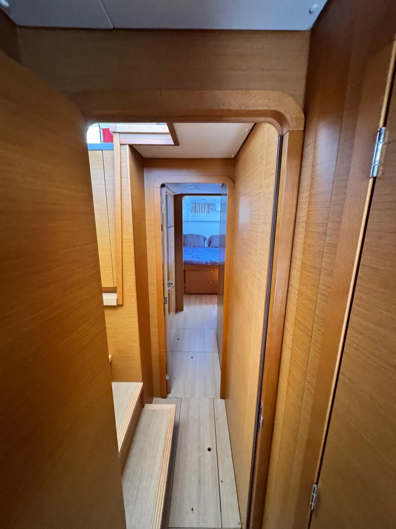Slide: The Image of Interior hallway of 2016 Lagoon 450S yacht with wooden finish and visible bedroom. - 25
