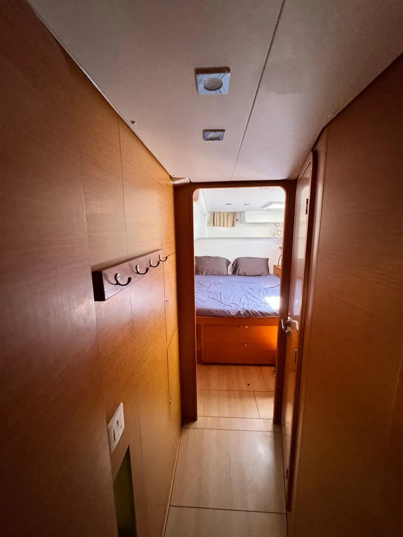 Slide: The Image of Interior view of 2016 Lagoon 450S yacht cabin with bed and wooden finish. - 26
