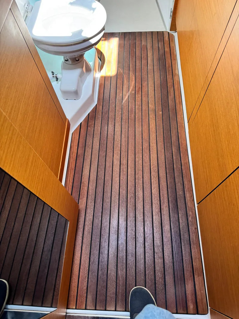 Slide: The Image of Interior of 2016 Lagoon 450S yacht bathroom with wooden flooring and toilet. - 31