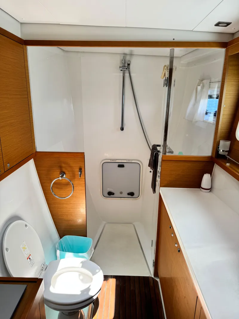Slide: The Image of 2016 Lagoon 450S yacht bathroom with shower, toilet, and wooden cabinetry. - 33