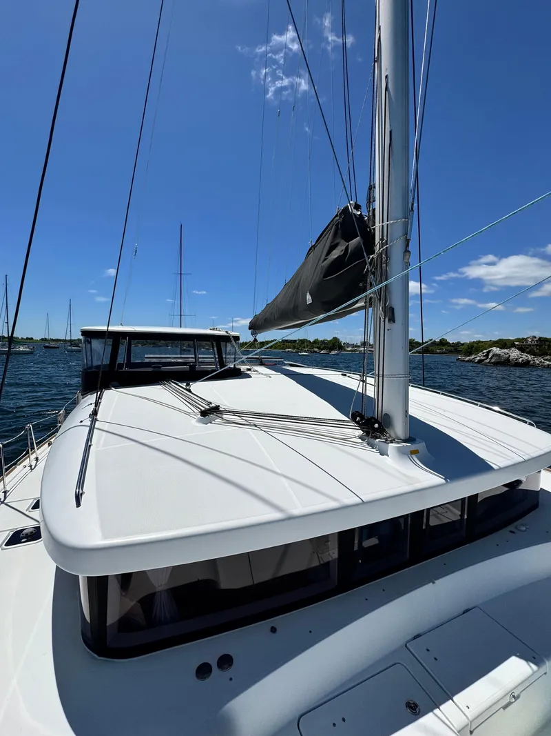 Slide: The Image of 2016 Lagoon 450S catamaran on water, clear sky, and scenic background. - 4