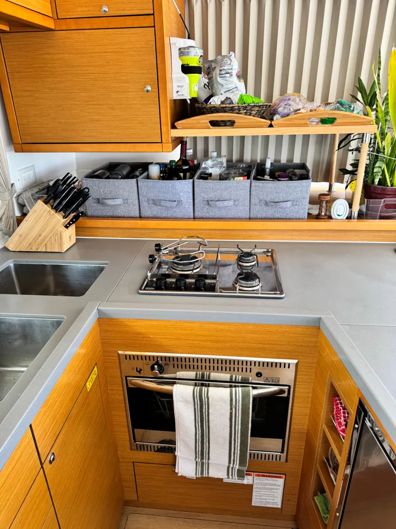 Slide: The Image of Compact kitchen in a 2016 Lagoon 450S yacht with stove, oven, and organized storage. - 40