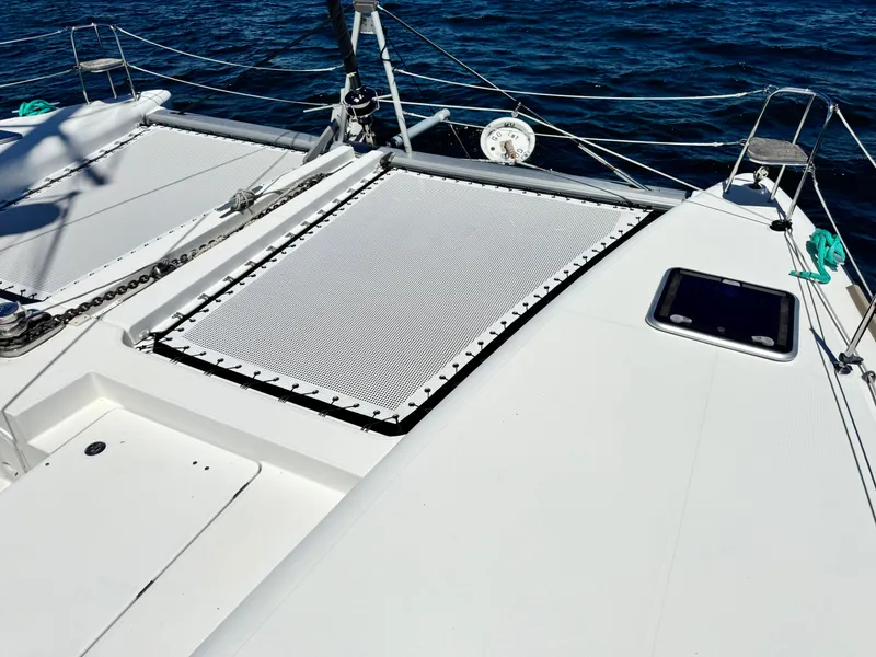 Slide: The Image of 2016 Lagoon 450S catamaran deck with netting, sailing on blue ocean waters. - 42