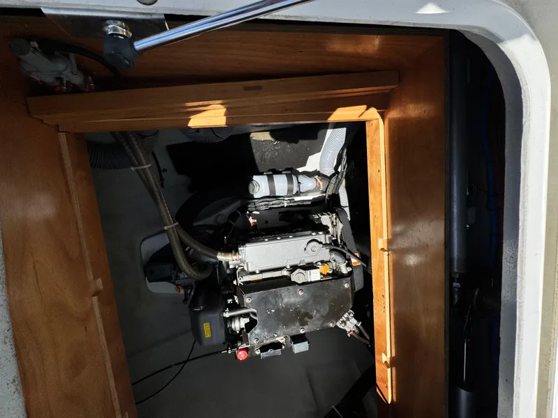 Slide: The Image of Engine compartment of a 2016 Lagoon 450S catamaran, featuring mechanical components and wooden paneling. - 52