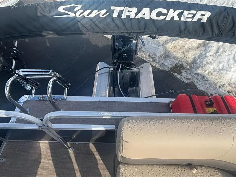 Slide: The Image of 2025 Sun Tracker PB 16 DLX pontoon boat with motor and seating, viewed from above. - 10
