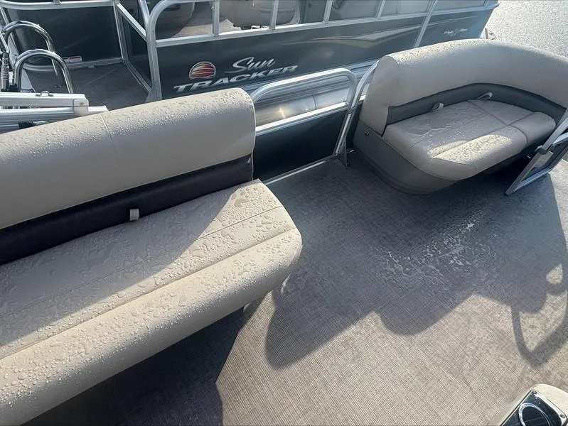 Slide: The Image of 2025 Sun Tracker PB 16 DLX pontoon boat interior with cushioned seating and carpeted floor. - 2