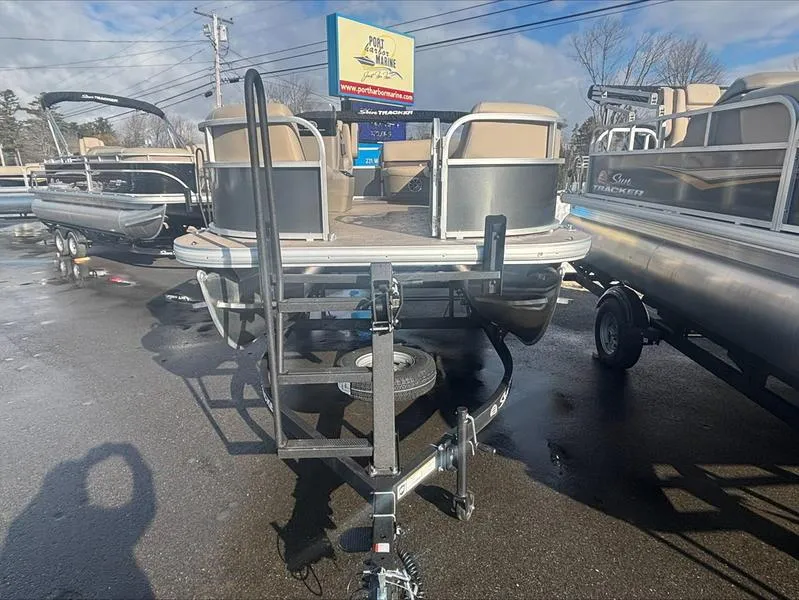 Slide: The Image of 2025 Sun Tracker PB 16 DLX pontoon boat on trailer in dealership lot. - 6