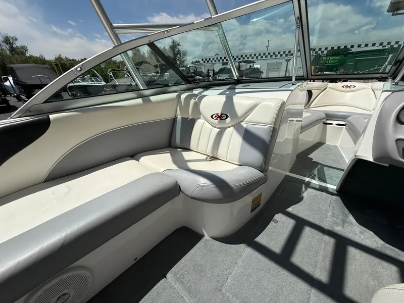 Slide: The Image of 2000 MasterCraft XStar boat interior with white and gray seating, glass windshield, and open deck. - 10