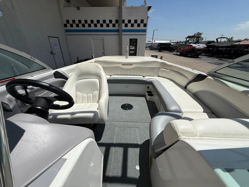 Slide: The Image of 2000 MasterCraft XStar boat interior with white seating and steering wheel. - 14