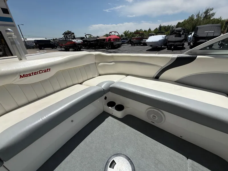 Slide: The Image of 2000 MasterCraft XStar boat interior with white and gray seating, outdoor setting. - 16