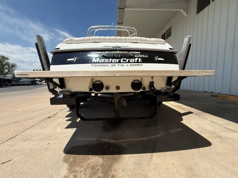 Slide: The Image of 2000 MasterCraft XStar boat rear view, parked outdoors, showcasing branding and design. - 7