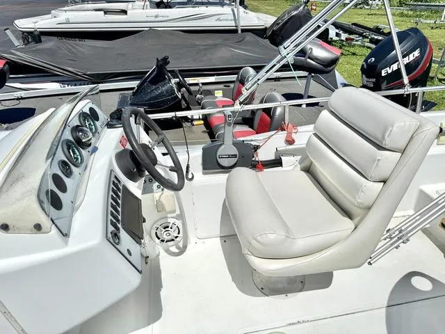 Slide: The Image of 1995 Hurricane Fundeck 230 boat interior with steering wheel and cushioned seating. - 5