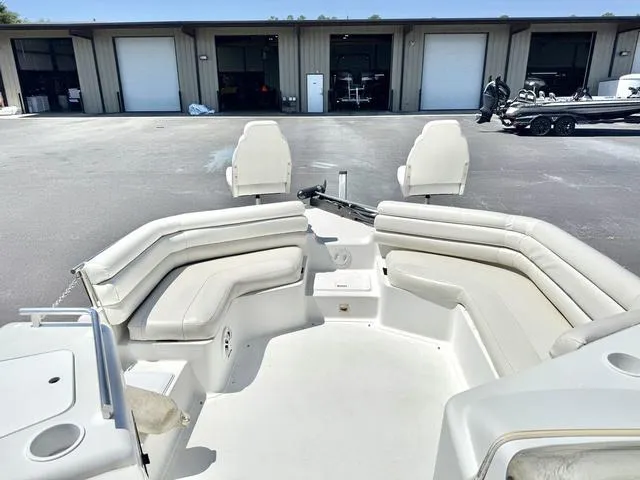 Slide: The Image of 1995 Hurricane Fundeck 230 boat with spacious seating, parked near storage units. - 7