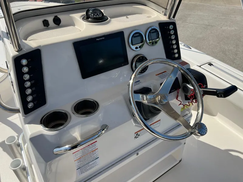 Slide: The Image of 2021 Robalo 226 Cayman boat dashboard with steering wheel and navigation controls. - 10