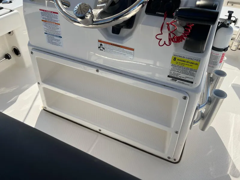 Slide: The Image of 2021 Robalo 226 Cayman boat console with steering wheel and storage compartments. - 14