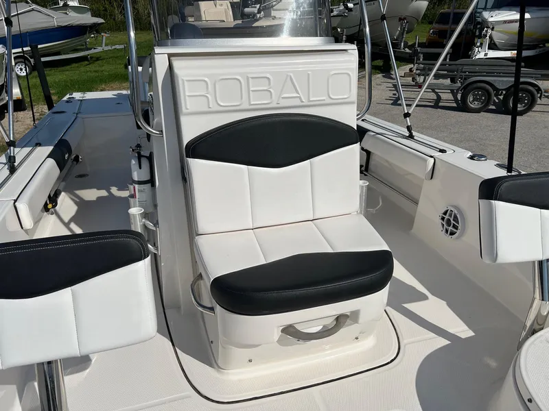 Slide: The Image of 2021 Robalo 226 Cayman boat interior with cushioned seating and sleek design. - 16