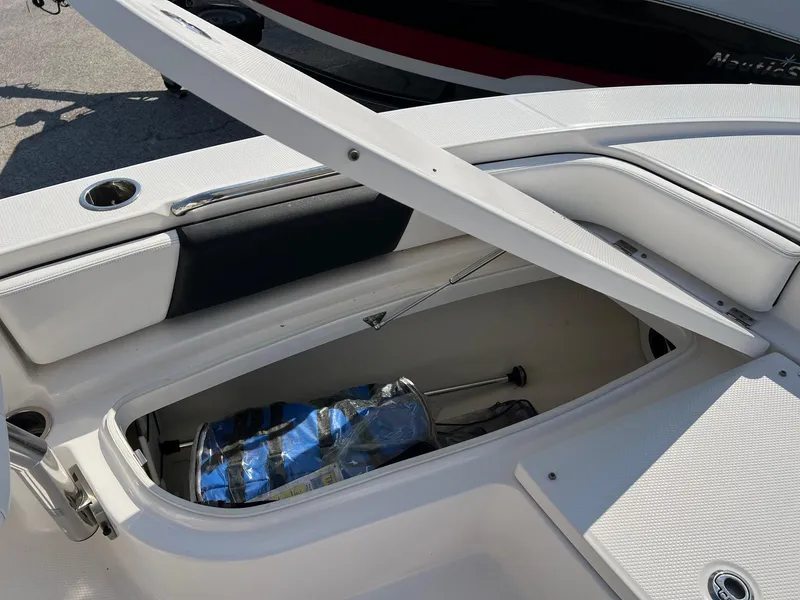 Slide: The Image of 2021 Robalo 226 Cayman boat storage compartment open, showcasing interior space. - 22