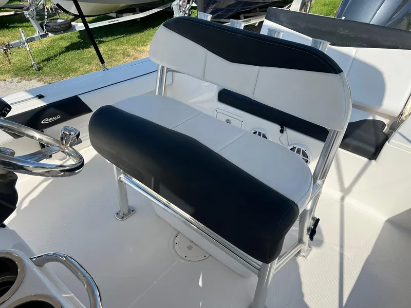 Slide: The Image of 2021 Robalo 226 Cayman boat interior with black and white seating and steering wheel. - 23