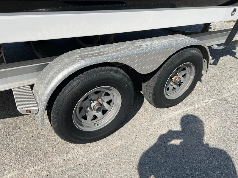 Slide: The Image of Trailer wheels of a 2021 Robalo 226 Cayman boat on pavement. - 3
