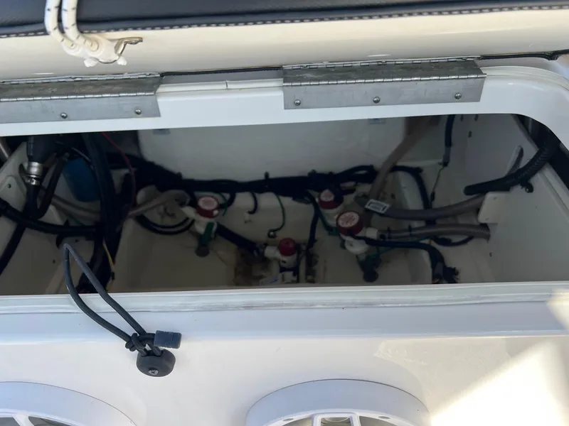Slide: The Image of 2021 Robalo 226 Cayman boat storage compartment with visible wiring and components. - 9