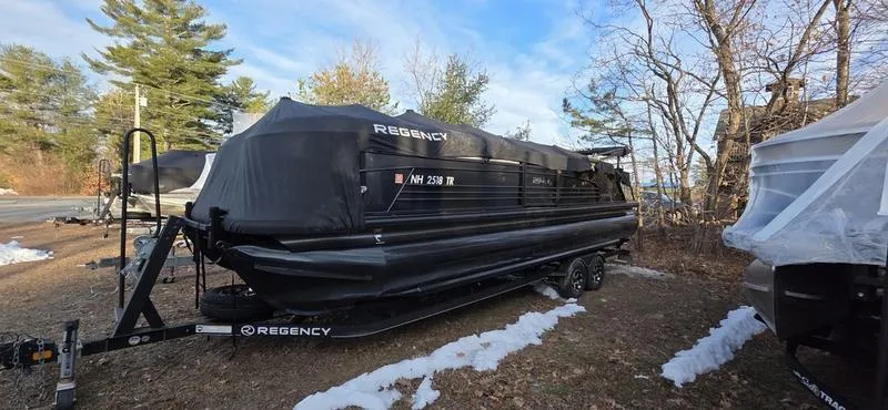 Slide: The Image of 2017 Regency 254 LE3 Sport boat covered and parked outdoors in a wooded area. - 13