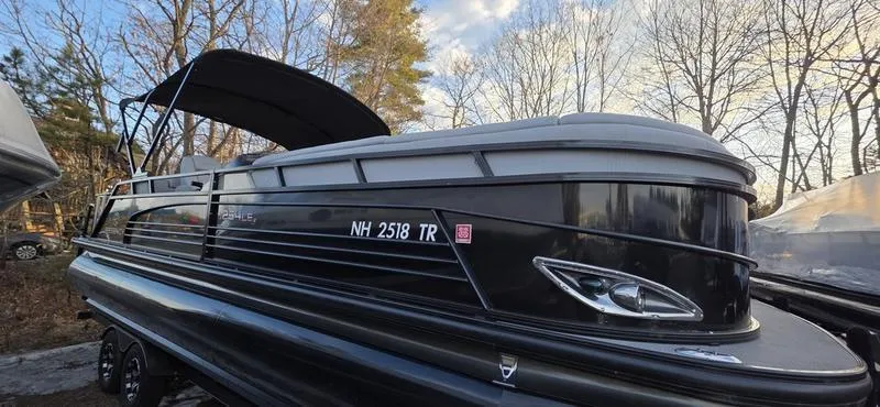 Slide: The Image of 2017 Regency 254 LE3 Sport pontoon boat with black exterior, parked outdoors. - 2