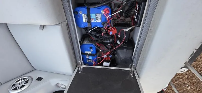 Slide: The Image of 2017 Regency 254 LE3 Sport boat battery compartment with wiring and components. - 5