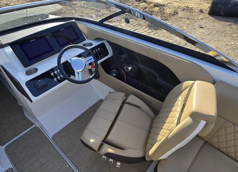 Slide: The Image of 2019 Sea Ray SLX 230 boat interior with beige seating and modern dashboard. - 4