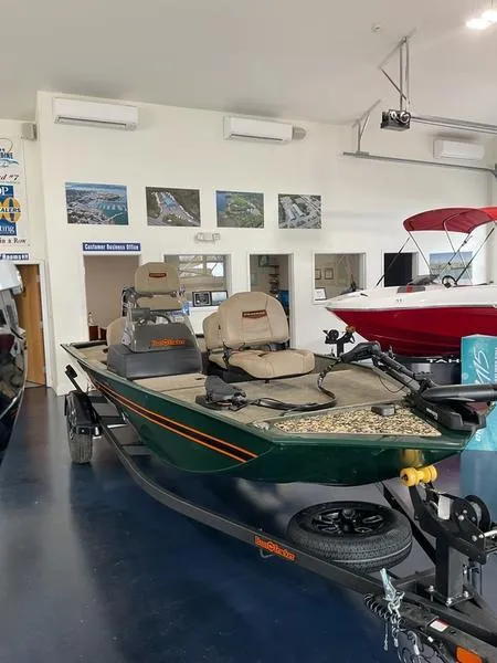 The Image of 2025 Tracker BT CLASSIC SE boat displayed in showroom with fishing seats and trailer. - 0