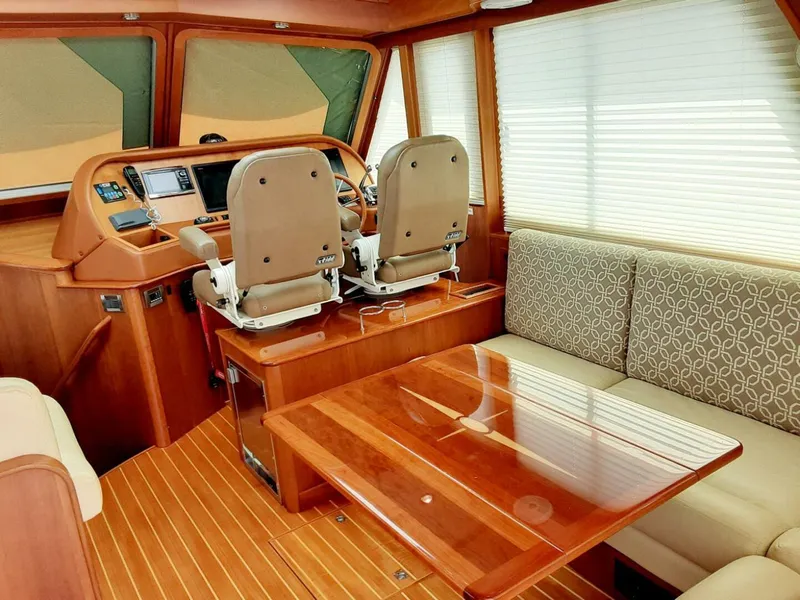Slide: The Image of 2016 Sabre 48 Salon Express interior with helm, seating, and wooden table. - 12