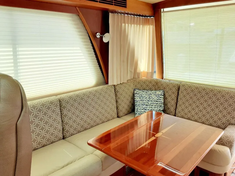 Slide: The Image of Interior of 2016 Sabre 48 Salon Express with elegant seating and wooden table. - 16