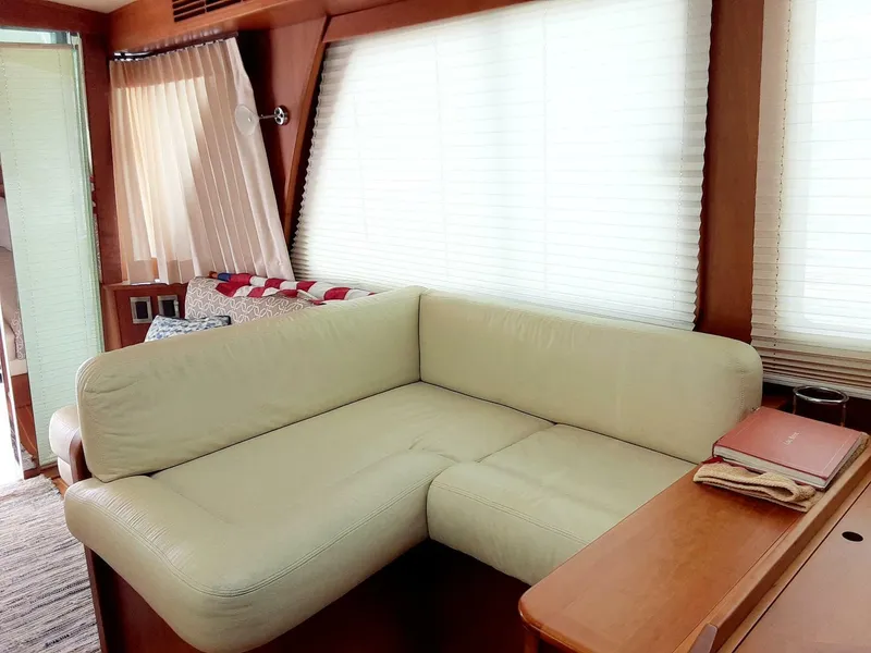 Slide: The Image of Interior of 2016 Sabre 48 Salon Express with cream L-shaped sofa and wooden accents. - 19