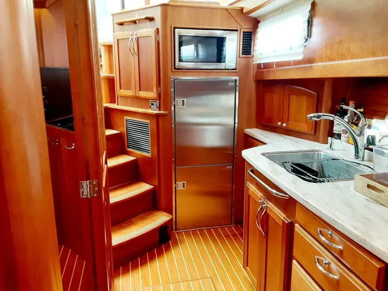 Slide: The Image of Interior of 2016 Sabre 48 Salon Express yacht with wooden cabinetry and modern kitchen amenities. - 21