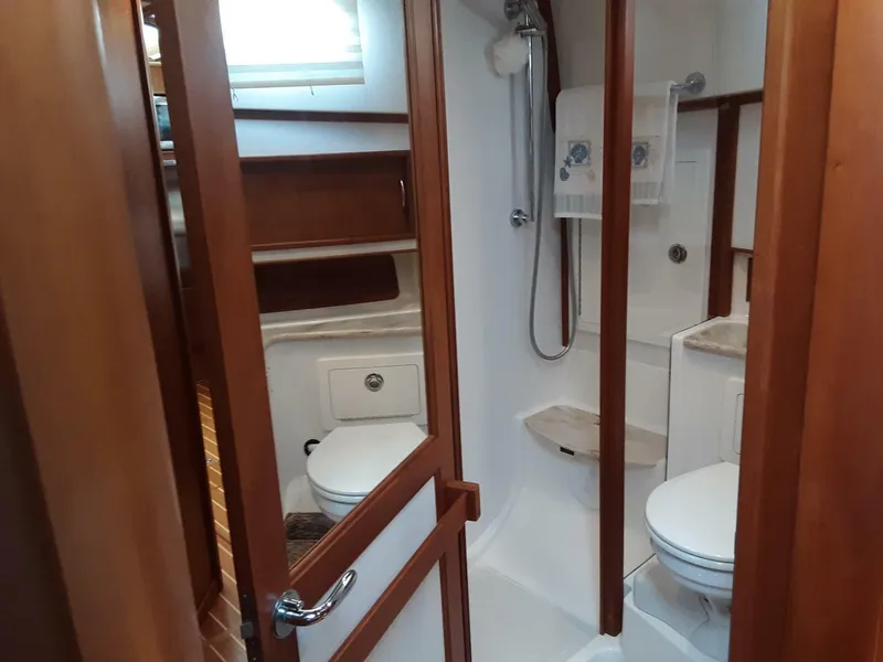 Slide: The Image of 2016 Sabre 48 Salon Express bathroom with shower, toilet, and wooden cabinetry. - 29