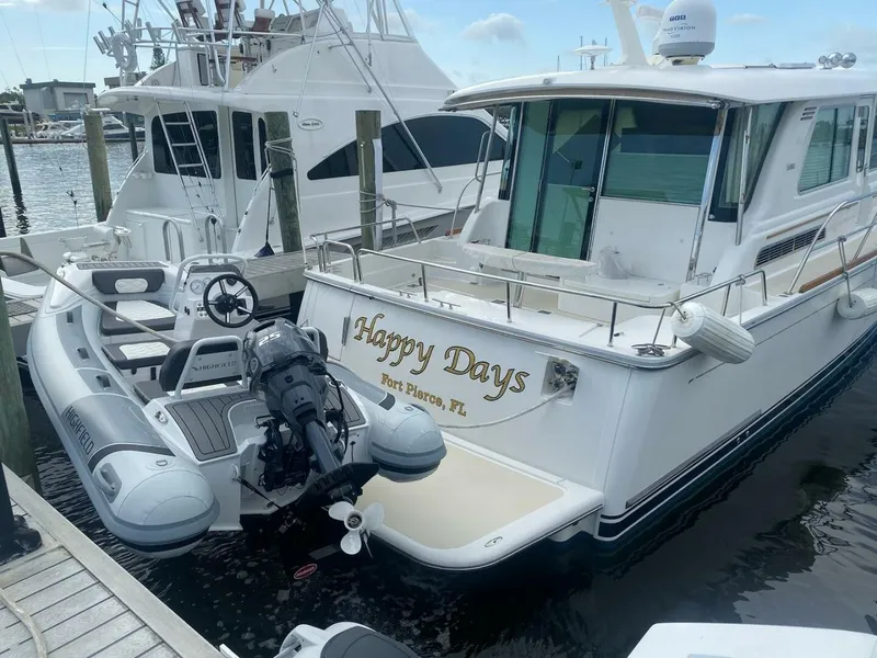 Slide: The Image of 2016 Sabre 48 Salon Express yacht named "Happy Days" docked with inflatable boat. - 7