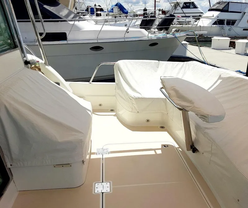 Slide: The Image of 2016 Sabre 48 Salon Express yacht deck with covered seating, docked at marina. - 9