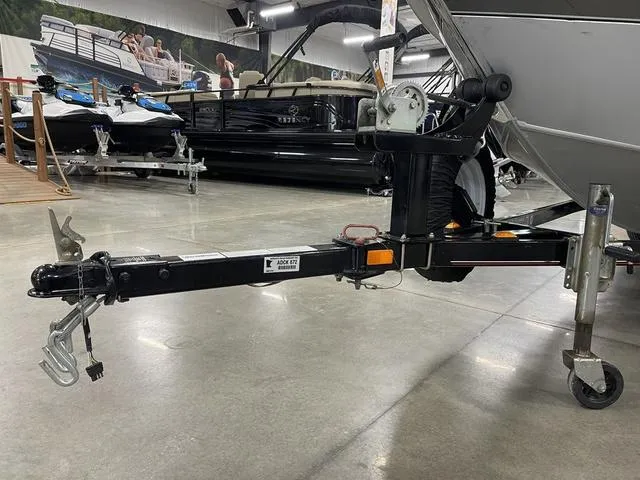 Slide: The Image of 2010 Tracker Pro-Guide V-16 SC boat trailer in showroom, featuring sturdy hitch and wheel assembly. - 15