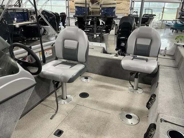 Slide: The Image of 2010 Tracker Pro-Guide V-16 SC boat interior with two gray seats in a showroom. - 25