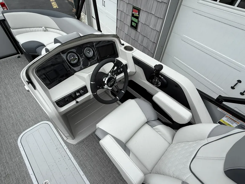 Slide: The Image of 2025 Avalon LSZ Quad Lounger boat interior with steering wheel and seating. - 19