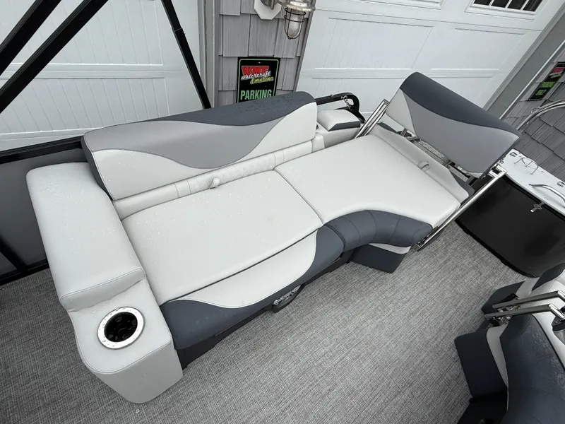 Slide: The Image of 2025 Avalon LSZ Quad Lounger boat seat with cup holder, featuring sleek gray and white design. - 22