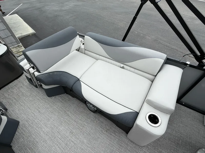Slide: The Image of 2025 Avalon LSZ Quad Lounger boat seat with cup holder, featuring sleek gray upholstery. - 23
