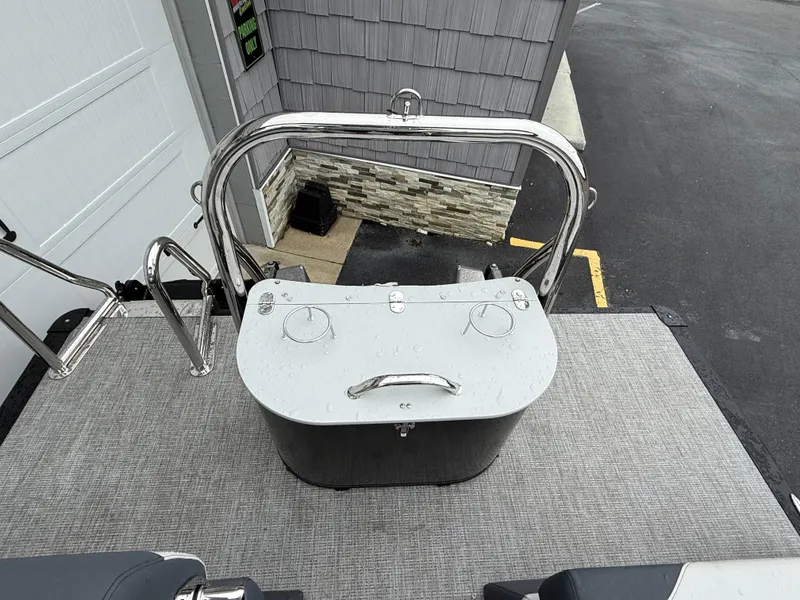 Slide: The Image of 2025 Avalon LSZ Quad Lounger boat deck with stainless steel railing and storage compartment. - 25