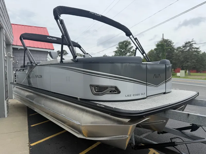 Slide: The Image of 2025 Avalon LSZ Quad Lounger 24' Tri Toon High Performance pontoon boat, parked outdoors. - 9