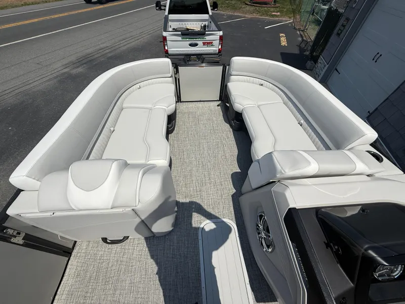 Slide: The Image of 2025 Avalon 2385 Catalina Quad Lounger interior with plush seating, parked near a road. - 17