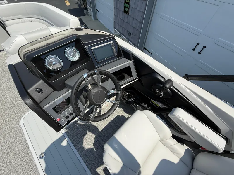 Slide: The Image of 2025 Avalon Catalina Quad Lounger boat dashboard with steering wheel and controls. - 24